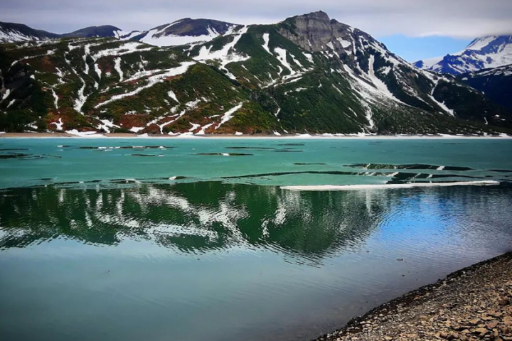 a body of water with a mountain in the background