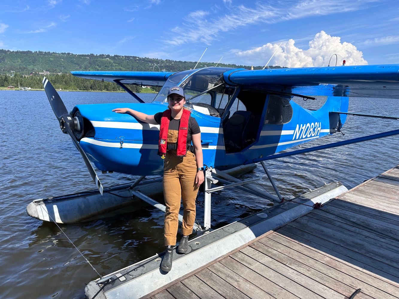 a person sitting on a dock next to a body of water